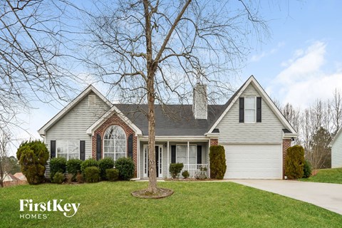 a home with a large tree in the front yard